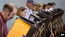 FILE - Voters use electronic voting machines at the Schiller Recreation Center polling station on election day, Nov. 3, 2015, in Columbus, Ohio.