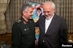 Islamic Revolutionary Guard Corps (IRGC) commander Mohammad Ali Jafari, left, and Iran's Foreign Minister Mohammad Javad Zarif smile during a coordination meeting for the 40th anniversary of the Islamic Revolution, in Tehran, Iran, Oct. 9, 2017.