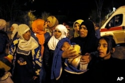 FILE - People wait to leave the besieged town of Madaya, northwest of Damascus, Syria, on Jan. 11, 2016.