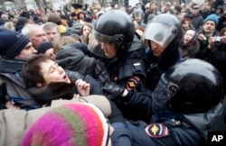 FILE - Russian police officers detain opposition activists outside a court room in Moscow, Russia, Monday, Feb. 24, 2014, where hearings started against opposition activists detained on May 6, 2012 during a rally at Bolotnaya Square.