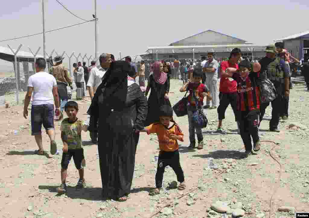 Families fleeing the violence in Mosul wait at a checkpoint on the outskirts of Irbil, Iraq, June 10, 2014.
