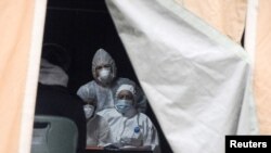 Arhiva - Zdravstveni radnici u zaštitnim odelima, tokom borbe protiv epidemije koronavirusa u Prištini, Kosovo, 25. marta 2020. (REUTERS/Laura Hasani)