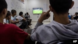 Juveniles linked to the Islamic State group watch a game in a rehabilitation center outside Qamishli, Syria, May 11, 2023.