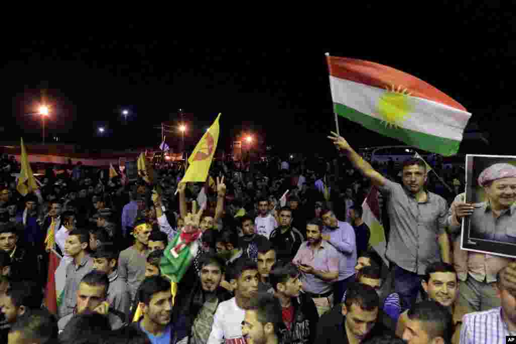 Thousands of supporters of Kurdish Peshmerga forces gather to celebrate as they wait for the troops to cross the border into Turkey en route to Kobani, at the Ibrahim Khalil border crossing, in the Northern Kurdish Region of Iraq, Oct. 29, 2014.