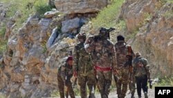 Anggota Pasukan Demokratik Suriah (SDF) berpatroli dekat desa Baghuz, kawasan pedesaan Suriah, 20 Maret 2019.