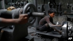 FILE - A boy, 11, works at a factory that makes metal utensils in Dhaka, Bangladesh, June 12, 2016. 