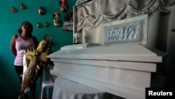 Karina Navarrete stands next to the coffin of her 15-month-old son Teiler Lorio Navarrete, who was shot during clashes between anti-government protesters and supporters of Nicaragua's President Daniel Ortega, in Managua, Nicaragua, June 23, 2018.