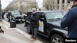 FILE - Chef Jose Andres gets ready with members of his World Central Kitchen team to load meals to deliver to needy people in downtown Washington, March 31, 2020.