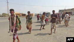 Yemeni fighters loyal to the Saudi-backed Yemeni president walk down a street in the town of Khokha in the western province of Hodeidah on Dec. 18, 2018. 