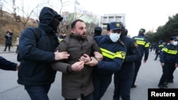 Police officers escort a protester away during an anti-government rally demanding new parliamentary elections in Tbilisi, Georgia Feb. 2, 2025.