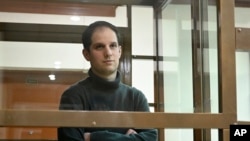 FILE - Wall Street Journal reporter Evan Gershkovich stands in a glass cage in a courtroom at the Moscow City Court, in Moscow, Russia, on Dec. 14, 2023. 