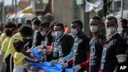 Volunteers stand ready to provide soap and water for participants to wash their hands against the new coronavirus at a women's 5km fun run in the capital Addis Ababa, Ethiopia, March 15, 2020.