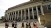 Orang-orang berjalan melewati pintu masuk Perpustakaan Widener di kampus Universitas Harvard, di Cambridge, Massachusetts, 16 Juli 2019. (Foto: AP)