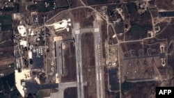 FILE - This handout image taken by EADS' Astrium Press on September 20, 2015, by Pleiades Satellite purports to show a view of Russian fighter jets and helicopters at a military base in Latakia, Syria.