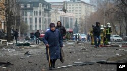 Люди у Києві на вулиці, всіяній уламками через російські атаки на Київ, 20 грудня 2024 р. AP Photo/Daniil Bashakov