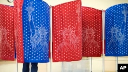 FILE - A voter marks a ballot inside a voting booth during a primary election, in Manchester, New Hampshire, Feb. 9, 2016.