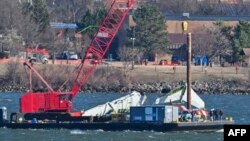 Спасательные команды ВМС США поднимают заднюю секцию крыла самолета American Airlines в Арлингтоне, штат Вирджиния, 4 февраля 2025 года.