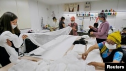 Members of a public association, which comprises people suffering from various types of cancer, produce medical masks in Bishkek, Kyrgyzstan, March 19, 2020. 