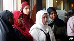 FILE - A group of women listen to Council on American-Islamic Relations-Minnesota Executive Director Jaylani Hussein, speaking about the Somali community concerns about the proposed government-initiated Countering Violent Extremism (CVE) program during a news conference in Minneapolis, Aug. 6, 2015.
