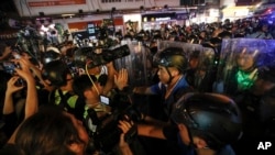 Journalists film policemen clearing a street in Hong Kong, July 7, 2019.