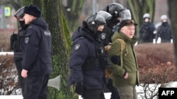 Police officers detain a man as people come to a monument to the victims of Soviet political repressions to lay flowers for late Russian opposition leader Alexei Navalny in St. Petersburg on Feb. 17, 2024, one day after the death of Navalny in an Arctic prison.