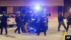 Armed police transport a man to a hospital after he's injured during unrest in Milwaukee, Aug. 14, 2016.