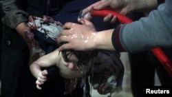 FILE - A child is treated in a hospital in Douma, eastern Ghouta, near Damascus, Syria, after an alleged chemical attack April 7, 2018. 