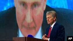 Arhiva - Portparol Kremlja Dimitrij Peskov tokom video-obraćanja ruskog predsednika Vladimira Putina preko videoskrina, u Moksvi, Rusija, 17. decembra 2020.