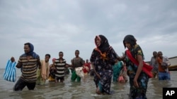 Sejumlah migran asal Ethiopia turun dari kapal dan berjalan menuju pesisir pantai di sebuah wilayah di Yaman, pada 26 Juli 2019. (Foto: AP/Nariman El-Mofty)
