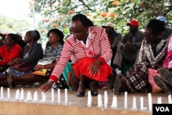 A relative lits a candle to remember her niece who died in the hands of al-Shabab gunmen in Garissa, northeastern Kenya. (Mohammed Yusuf/VOA)