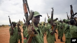 FILE - South Sudanese rebel soldiers raise their weapons at a military camp in the capital Juba, South Sudan, April 7, 2016. 