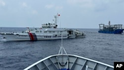 FILE - Two Chinese ships block a Philippine coast guard ship, foreground, headed for Second Thomas Shoal in the South China Sea, Oct. 4, 2023. The 2024 NATO summit is expected to touch on security and sovereignty issues in the area.