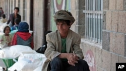 FILE - A boy waits for food supplies provided by the World Food Program (WFP) at a school in Sanaa, Yemen.