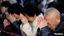 FILE - Believers take part in a weekend mass at an underground Catholic church in Tianjin, China, Nov. 10, 2013. China once again has been designated by the U.S. Commission on International Religious Freedom as a country of particular concern.