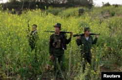 FILE - Rebel soldiers of Myanmar National Democratic Alliance Army (MNDAA) patrol near a military base in Kokang region, March 10, 2015.