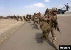 U.S. Marines prepare to depart at the end of operations for Marines and British combat troops in Helmand, Afghanistan, Oct. 27, 2014.