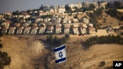 FILE - An Israeli flag is seen near the West Bank Jewish settlement of Maaleh Adumim on the outskirts of Jerusalem, Sept. 7, 2009.