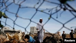 FILE - A Palestinian man inspects the scene of an Israeli air strike in the central Gaza Strip, Apr. 21, 2014. 