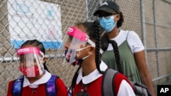 Students wear protective masks as they arrive for classes at the Immaculate Conception School while observing COVID-19 prevention protocols, Sept. 9, 2020, in The Bronx borough of New York.
