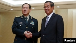 Chinese Defense Minister Wei Fenghe (L) shakes hands with Cambodia's Prime Minister Hun Sen before a meeting in Phnom Penh, Cambodia, June 18, 2018. REUTERS