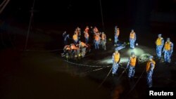 Rescue workers carry the body of a victim at the site where a cruise ship sank on Monday, in Jianli, Hubei province, June 4, 2015.