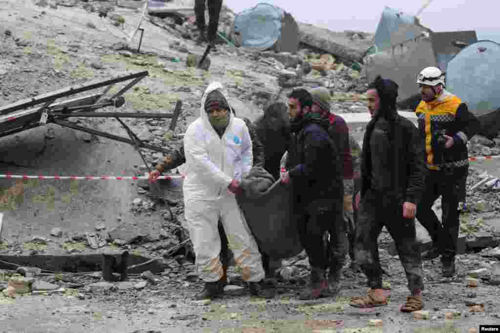 People carry a victim as rescuers search for survivors under the rubble, following an earthquake, in rebel-held town of Jandaris, Syria, Feb. 6, 2023.&nbsp;