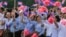FILE - Cambodian students are seen waving national flags during Independence Day celebrations in Phnom Penh.