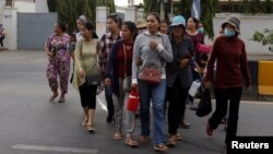 Garment workers leave for home after work at a factory, on the outskirts of Phnom Penh, Cambodia, Oct. 16, 2018. 