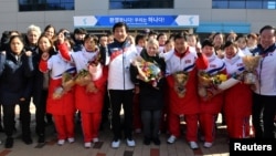 Sarah Murray, center, head coach of the combined women's ice hockey team is seen as North Korean women's ice hockey players arrive at the South Korea's national training center, Jan. 25, 2018, in Jincheon, South Korea.