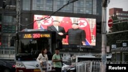 A television screen shows Chinese state media CCTV's footage of North Korean leader Kim Jong Un's meeting with Chinese President Xi Jinping in Pyongyang, at a street in Beijing, China, June 20, 2019