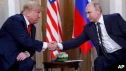 FILE - U.S. President Donald Trump (L) and Russian President Vladimir Putin shake hands at the beginning of a meeting at the Presidential Palace in Helsinki, Finland, July 16, 2018.