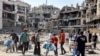 Ljudi prolaze pored ruševina i oštećenih zgrada u okrugu Tufa istočno od grada Gaze 8. jula 2024.