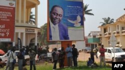 People stand under the poster of Central Africa Republic's President Francois Bozize in Bangui on December 28, 2012