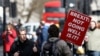 An anti-Brexit protester walks outside the Houses of Parliament in London, March 14, 2019.